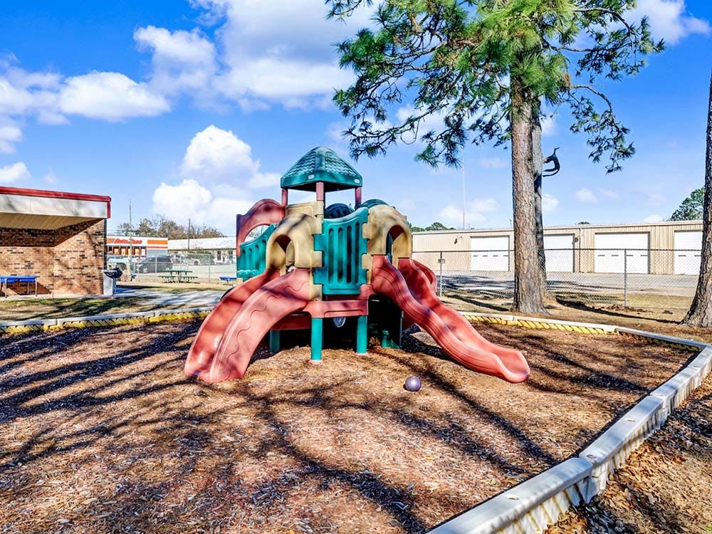 A colorful playground with slides and a climbing structure on a sunny day