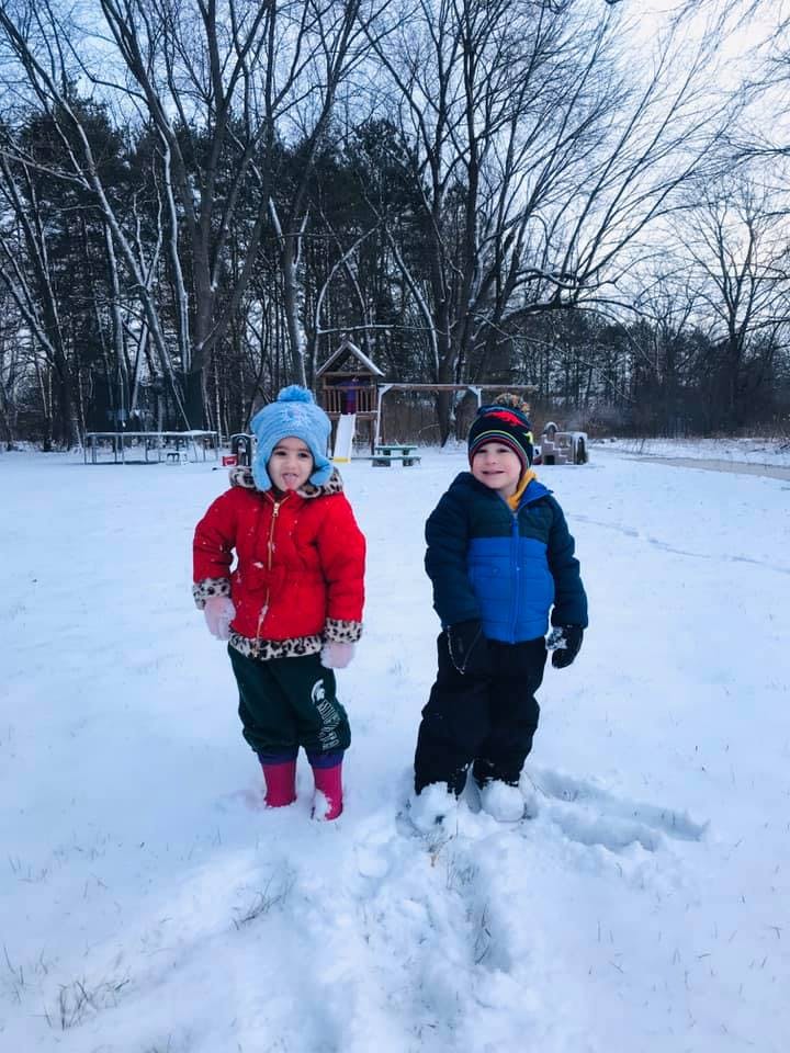 Two children standing in snow
