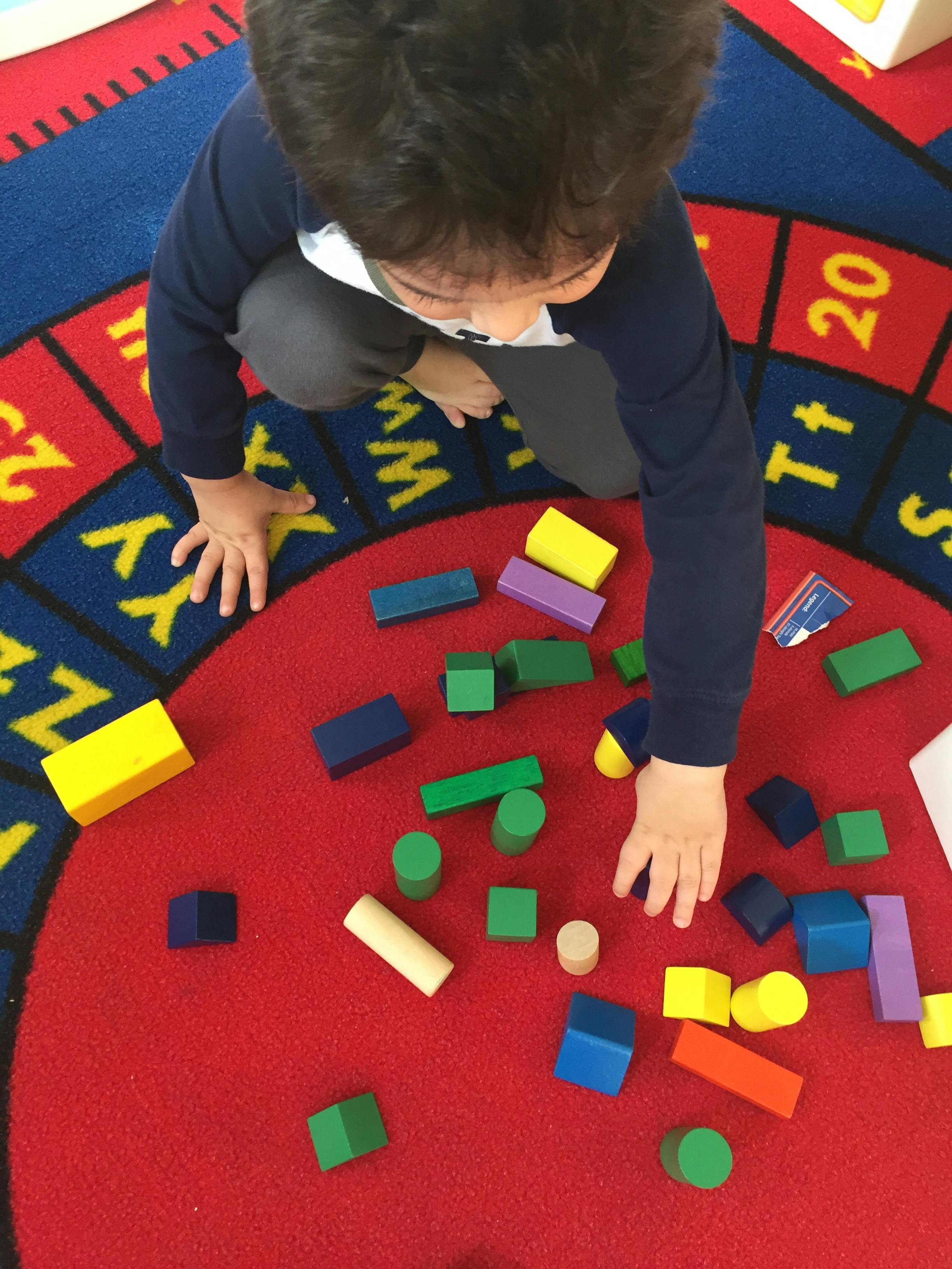 Child playing with building blocks on a rug