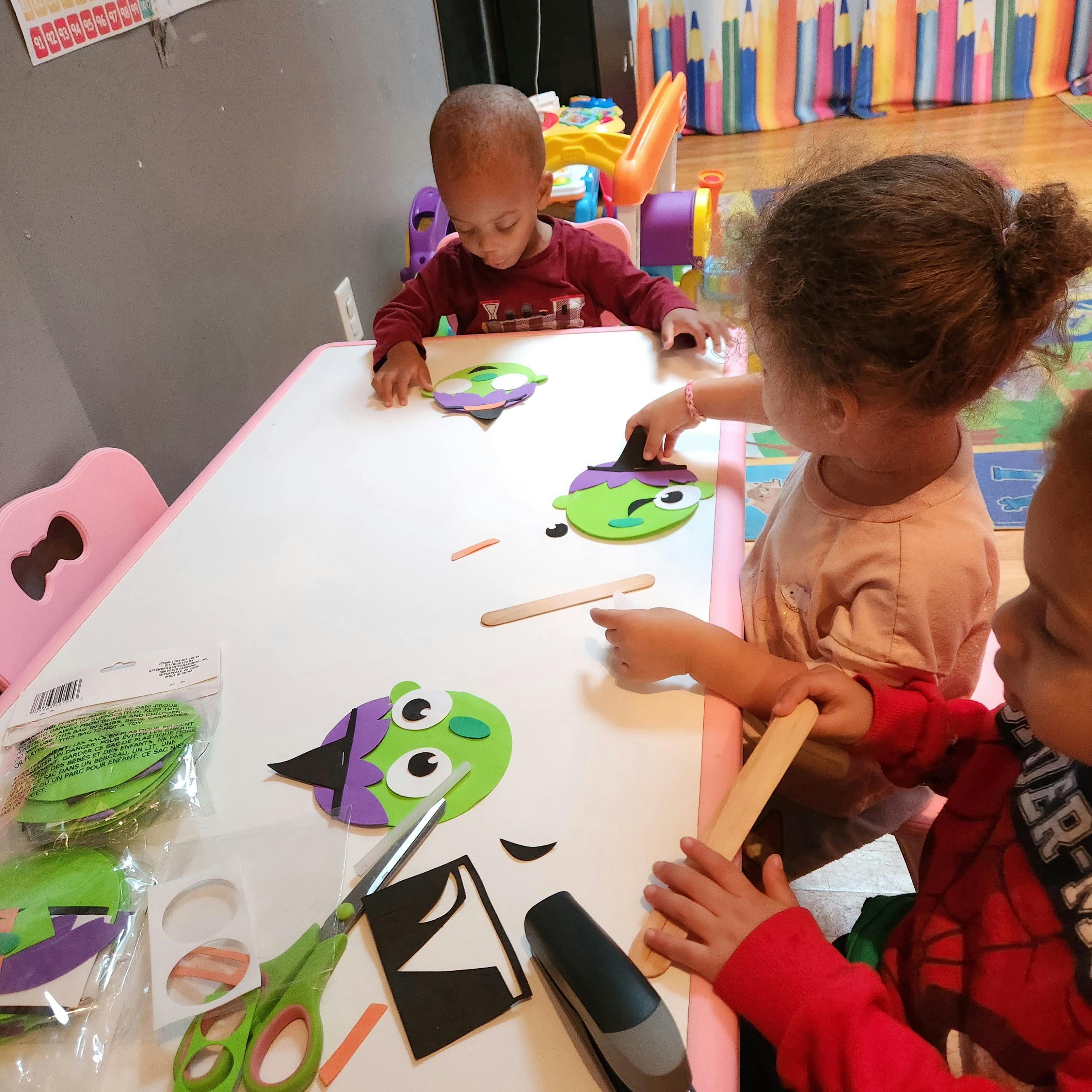 Children at a table doing crafts with craft supplies