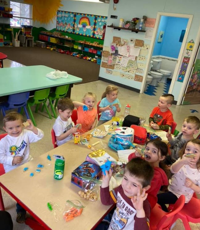 Children sitting at tables in a classroom