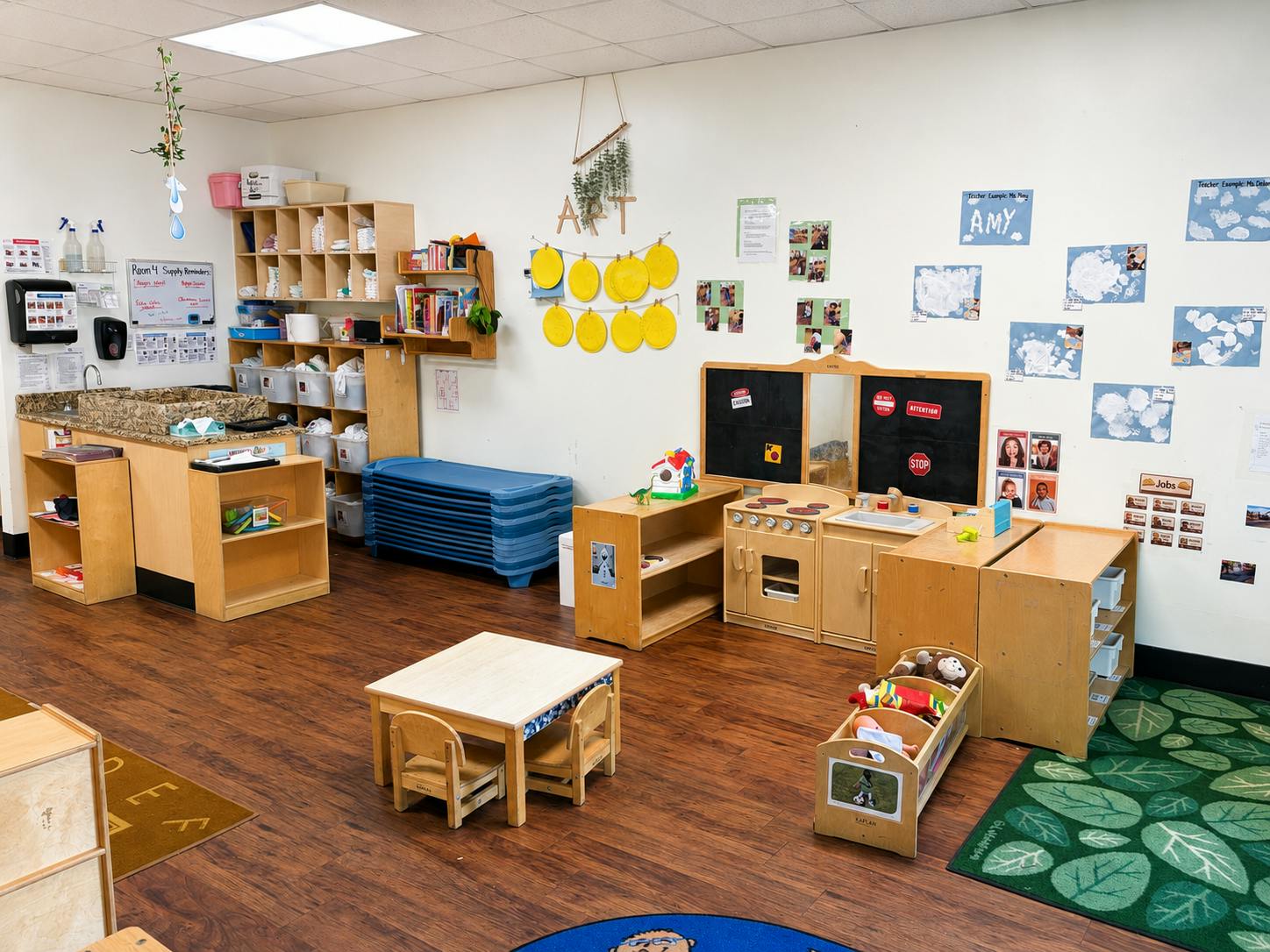 Childcare classroom interior with play kitchen and wooden furniture