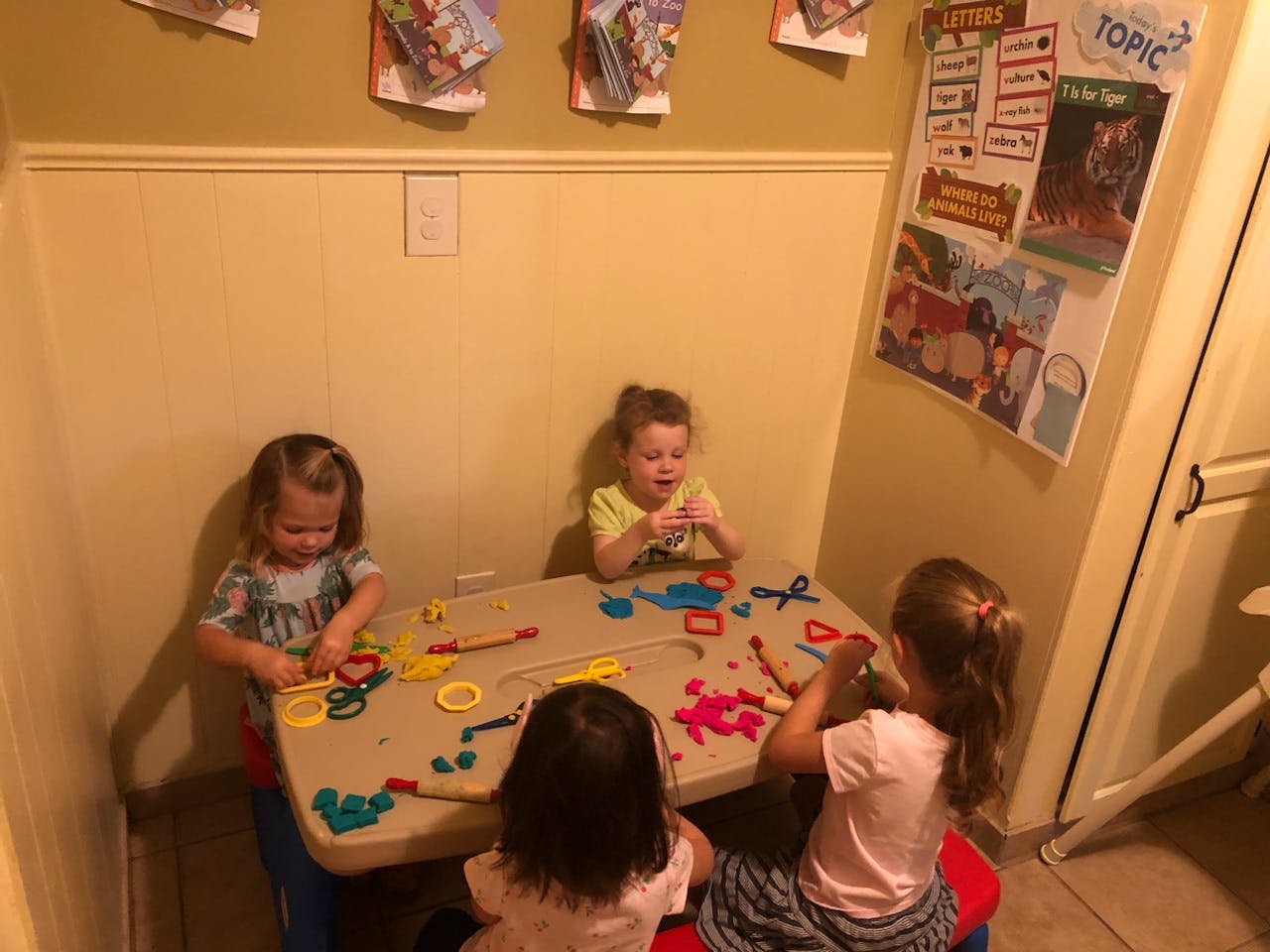 Three children playing with modeling clay at a table