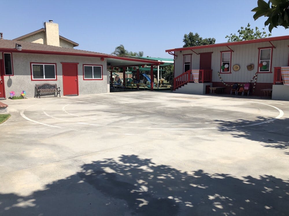 Two buildings with red doors and trim, connected by a covered walkway