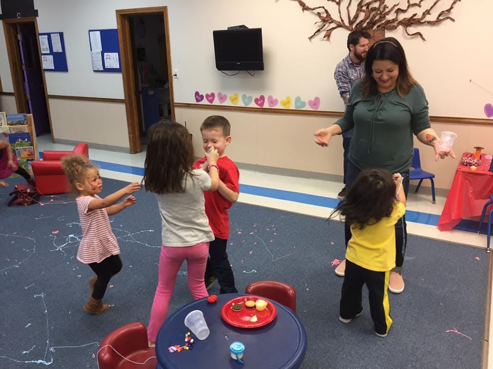 Adults and children playing in a room