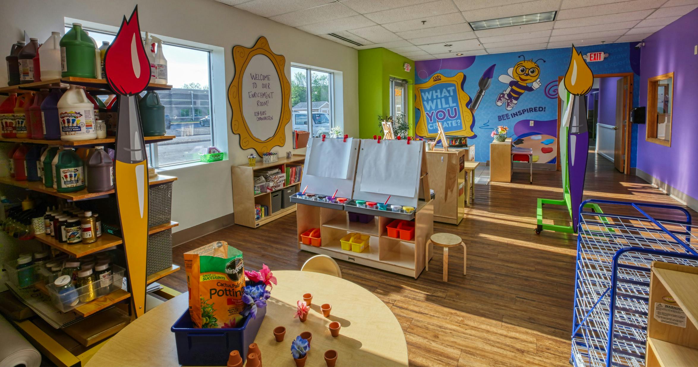 An art room with easels, paint, and a potting station