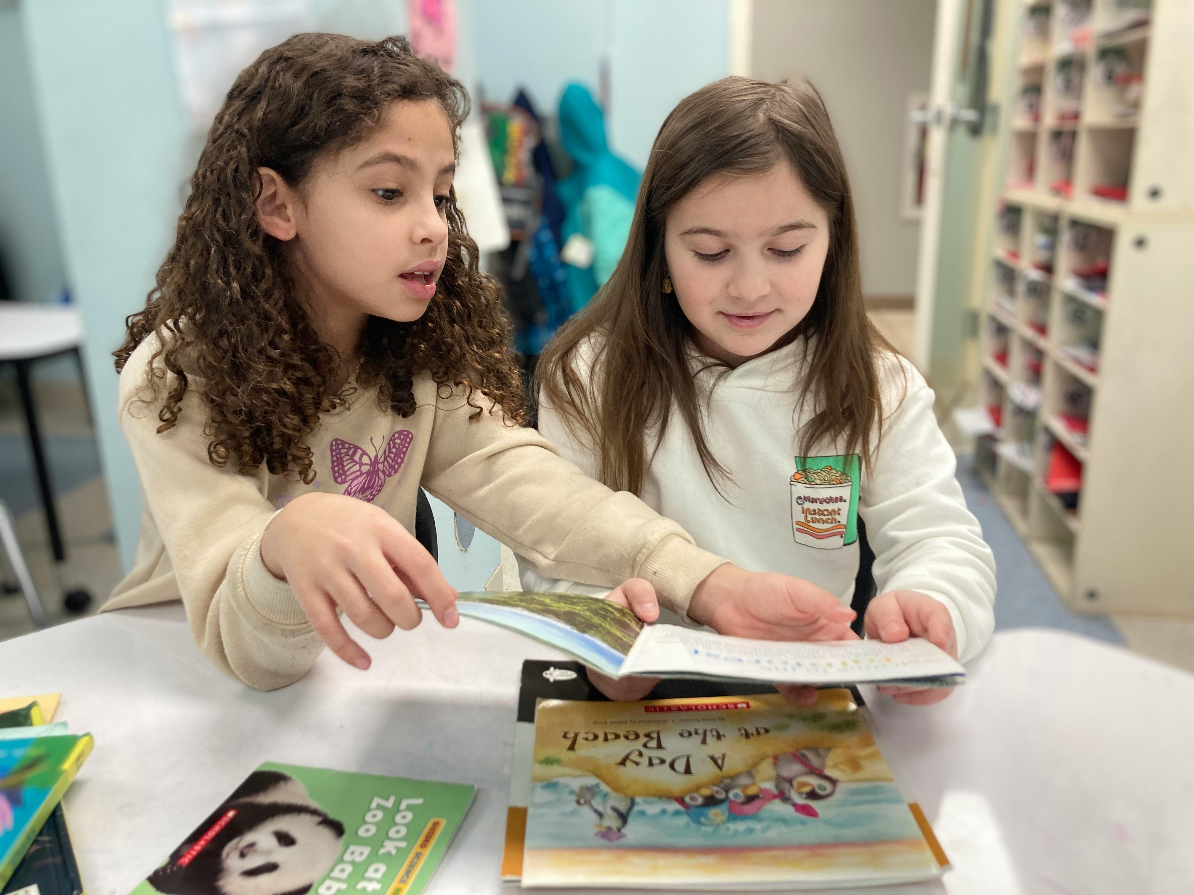 Two children reading books together