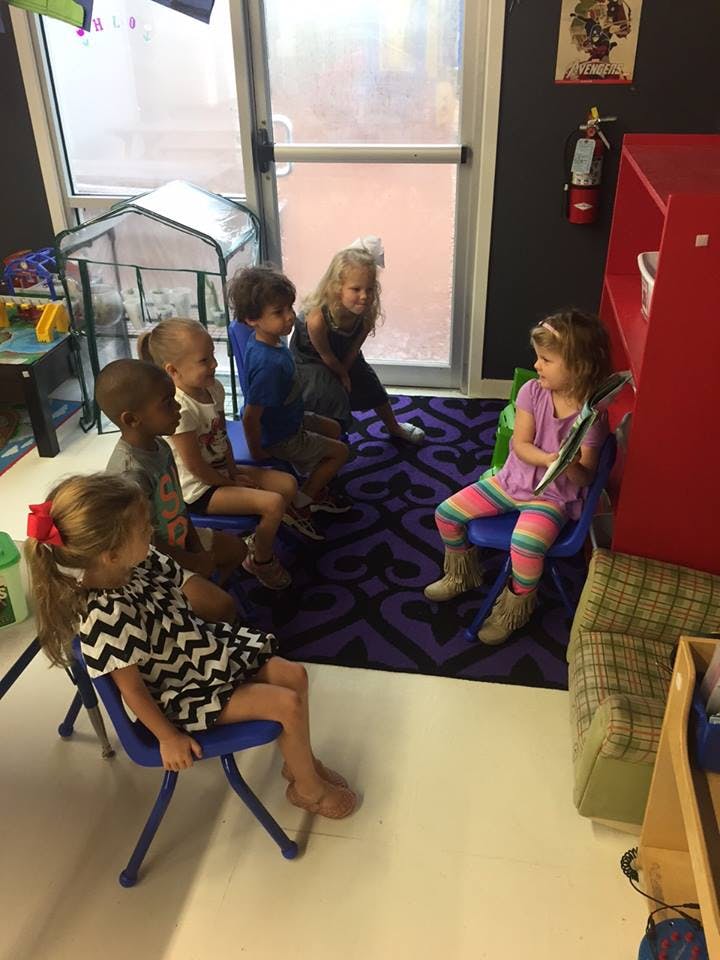 Children sitting on small chairs in a classroom