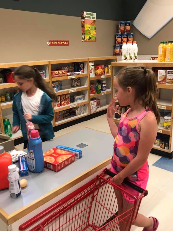 Two children playing in a pretend grocery store