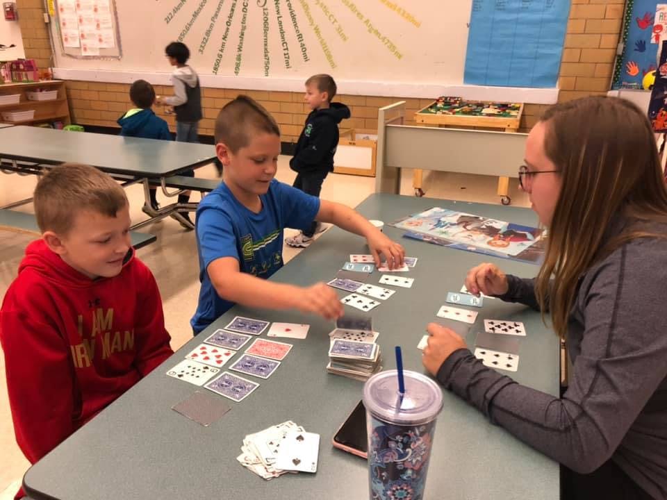 Three people playing cards at a table