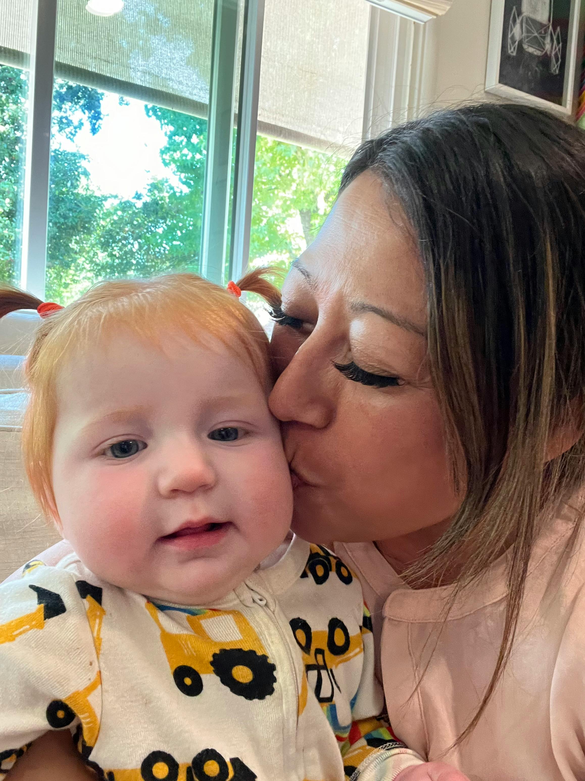 Person kissing a child on the cheek