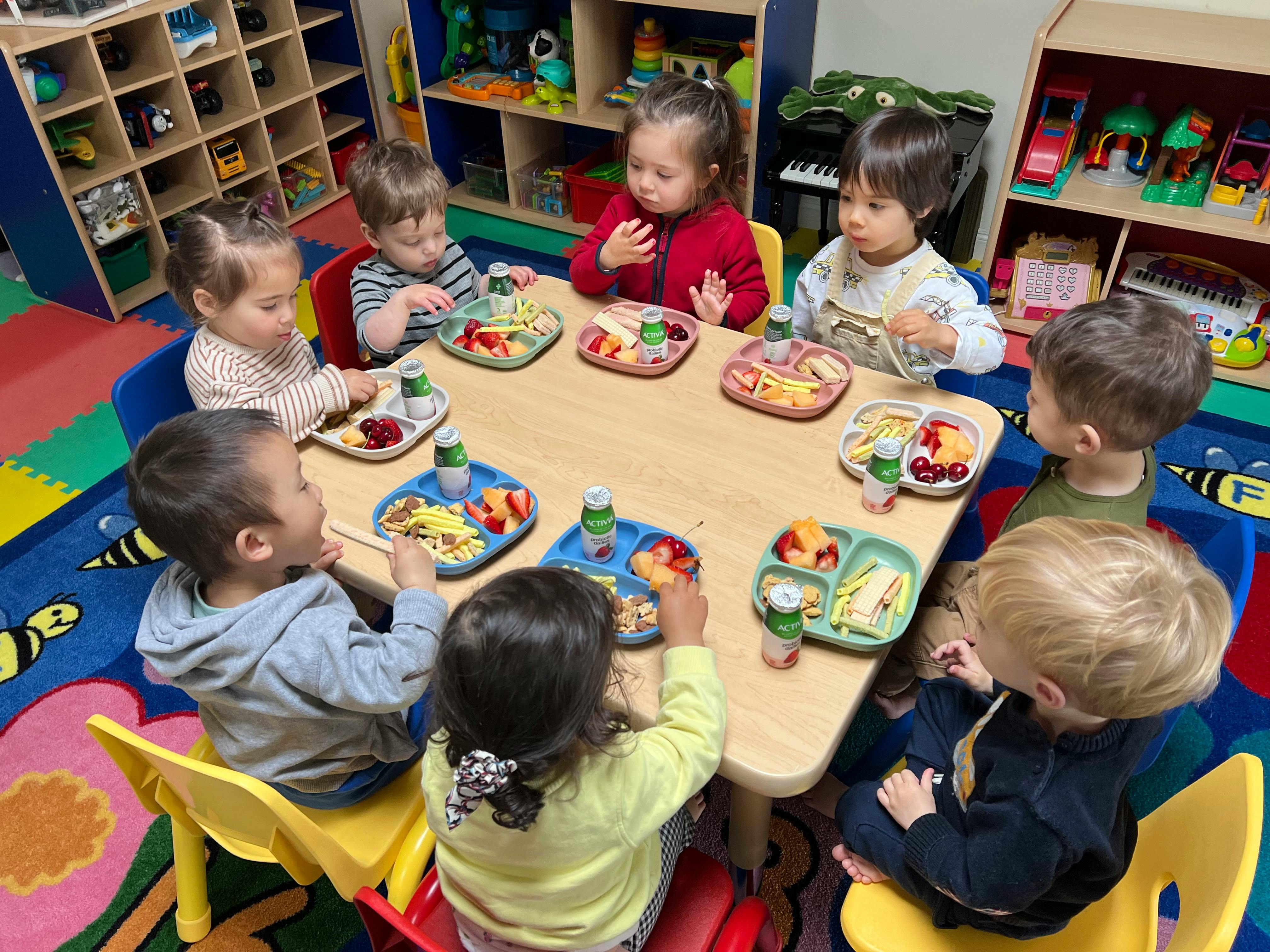 Children eating at a table in a classroom