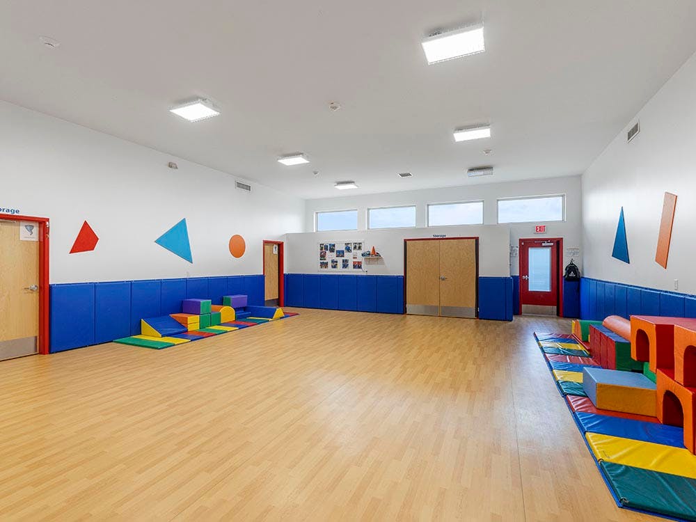 Colorful shapes on walls and soft play equipment in an indoor play area