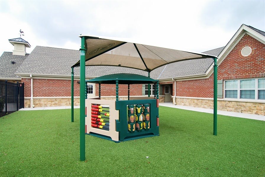 Play structure with a canopy on artificial grass