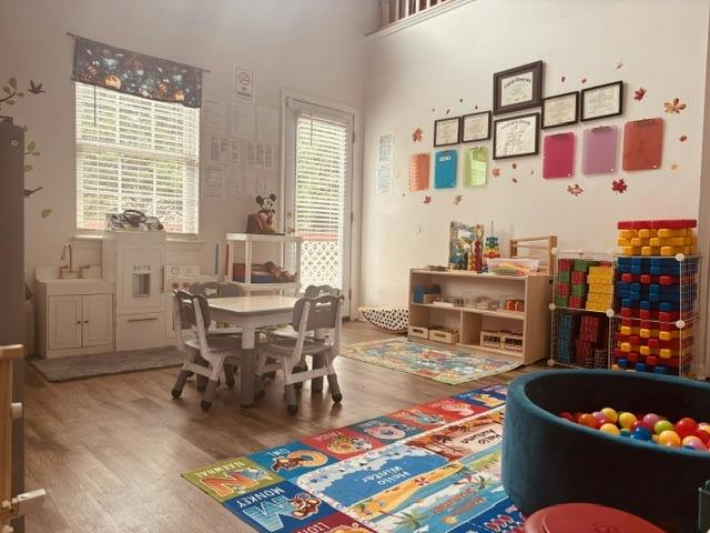Playroom with a small table, chairs, toys, and a ball pit