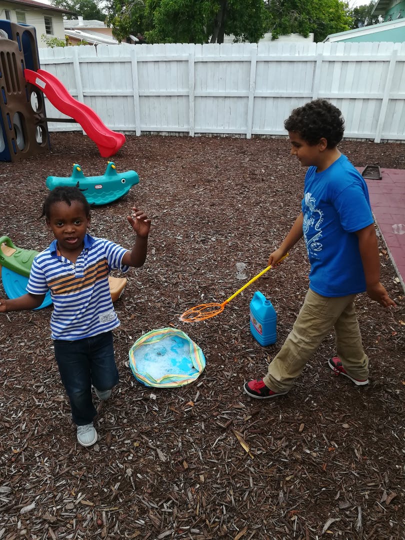 Two children playing with bubbles in a playground