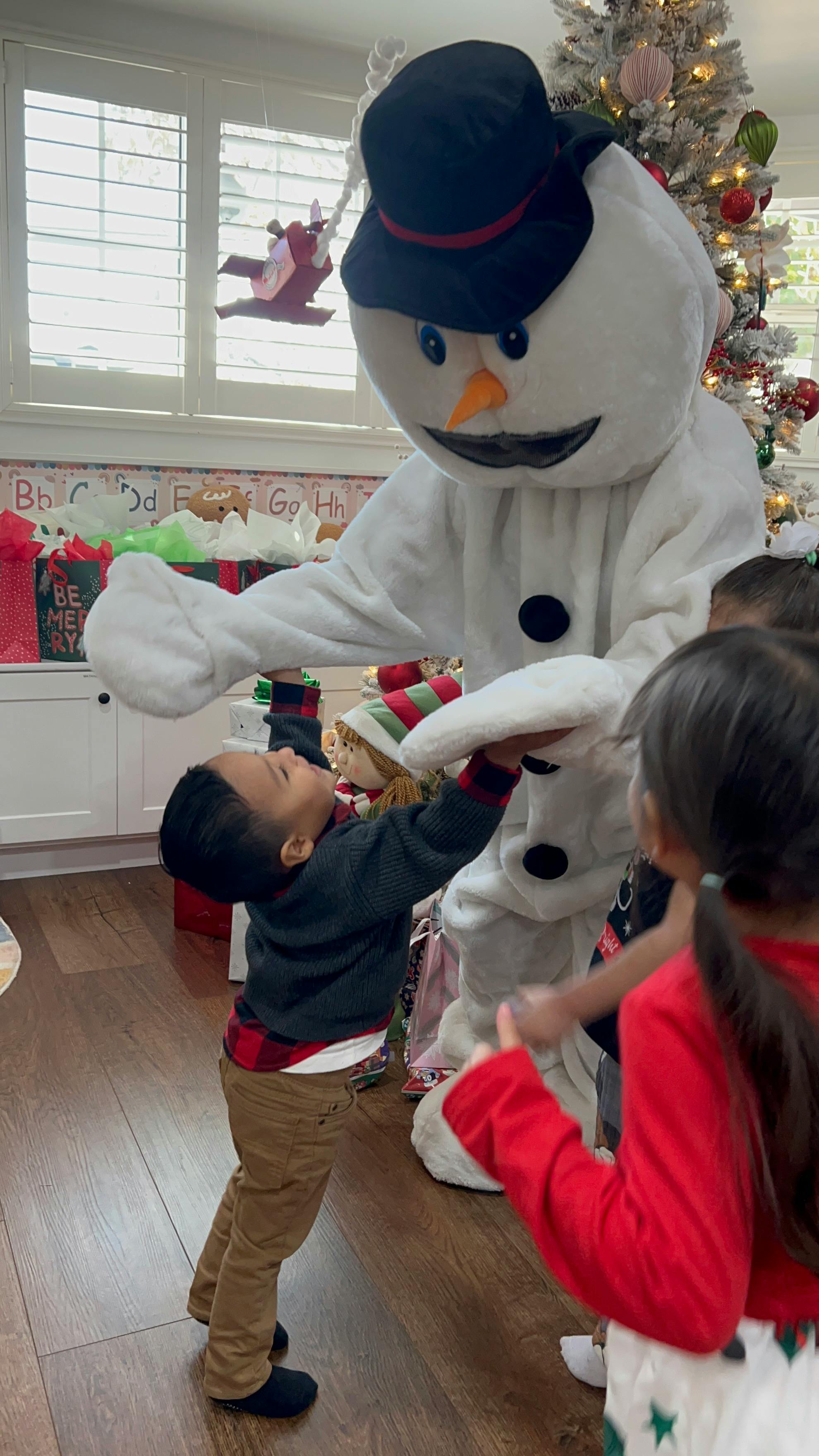 Child interacting with a person in a snowman costume