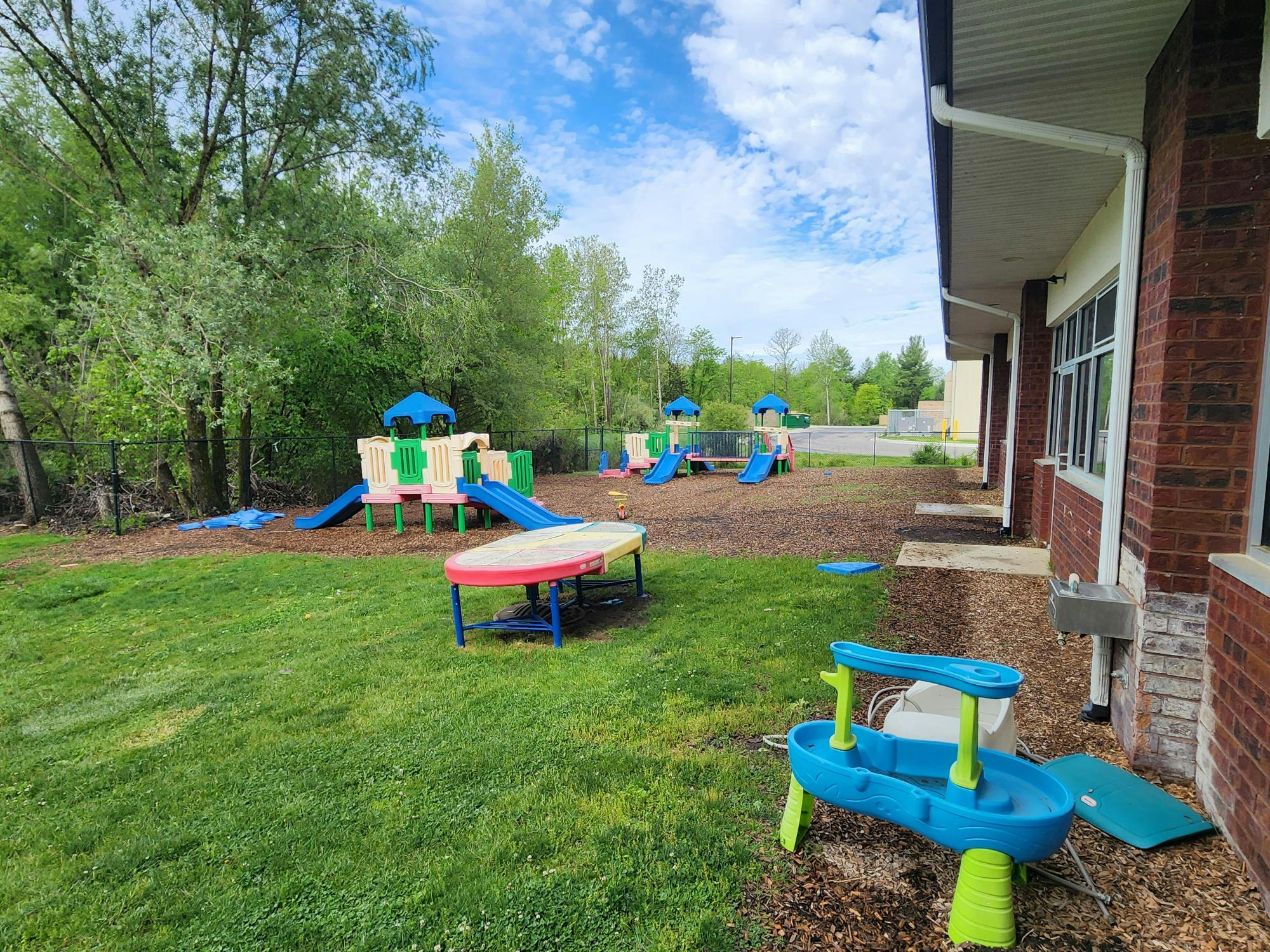 Playground equipment outside a brick building