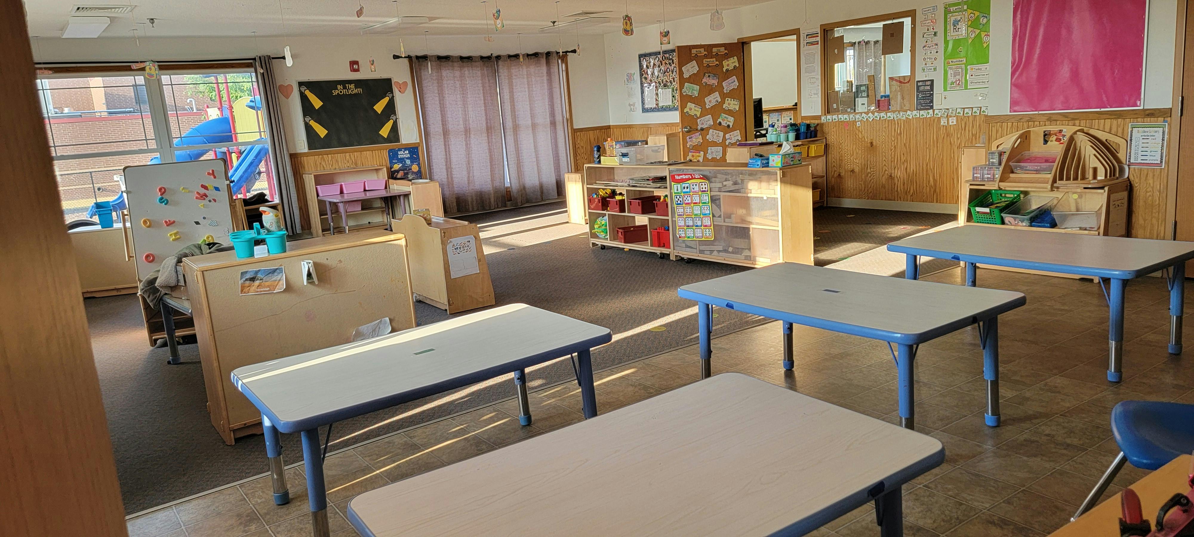 Empty classroom with small tables and chairs