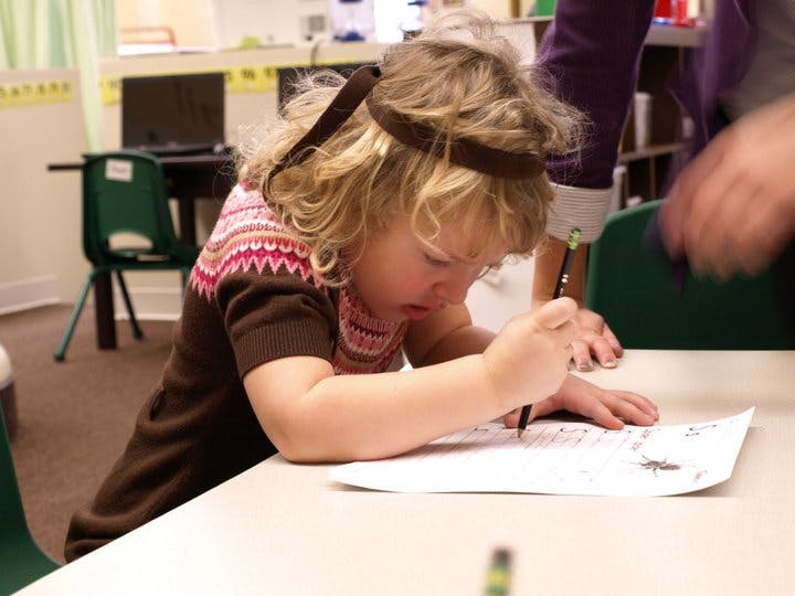 Child drawing on paper at a table