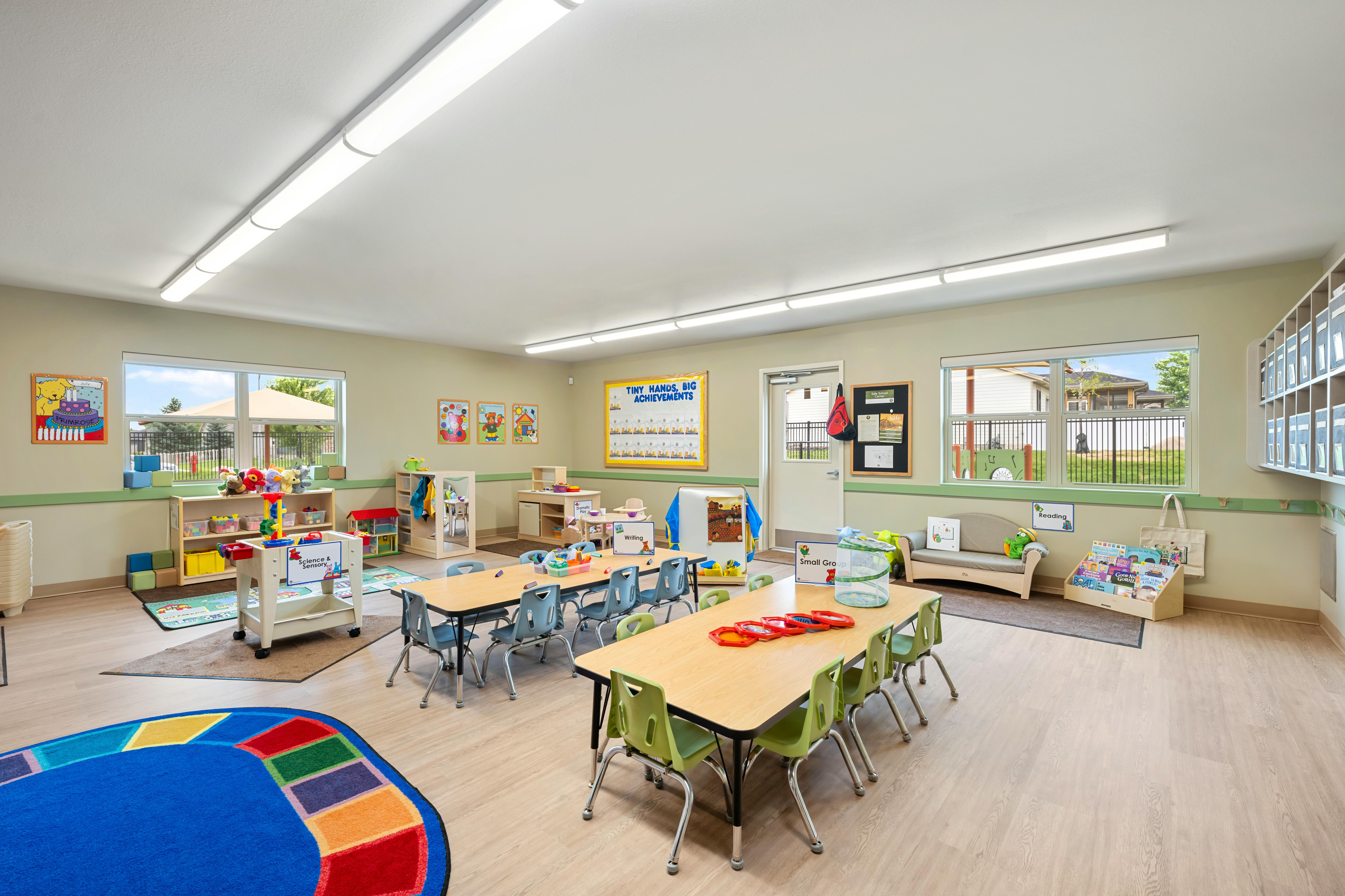 Classroom with child-sized tables and chairs, play areas, and educational displays