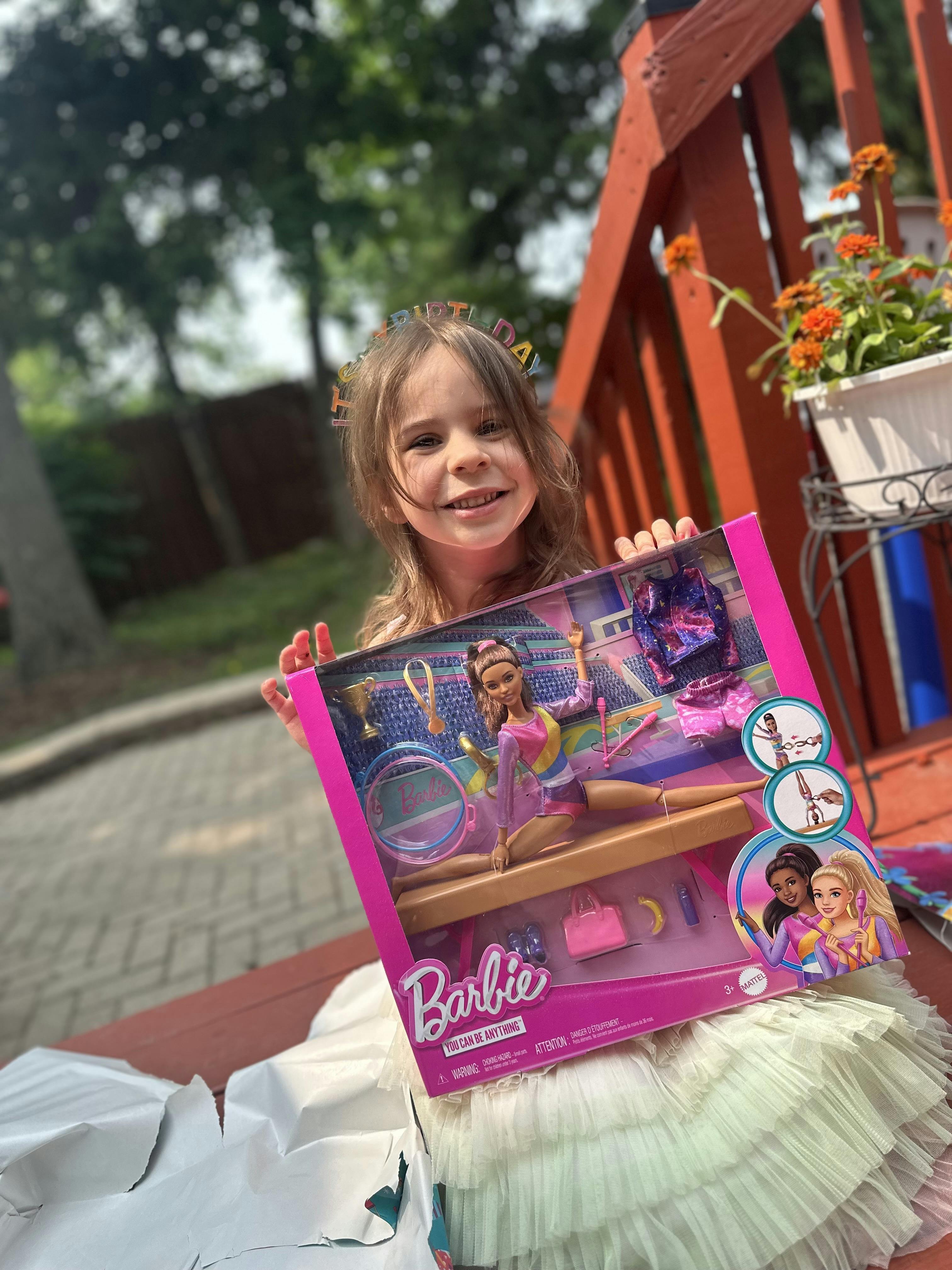 Child holding a Barbie doll box