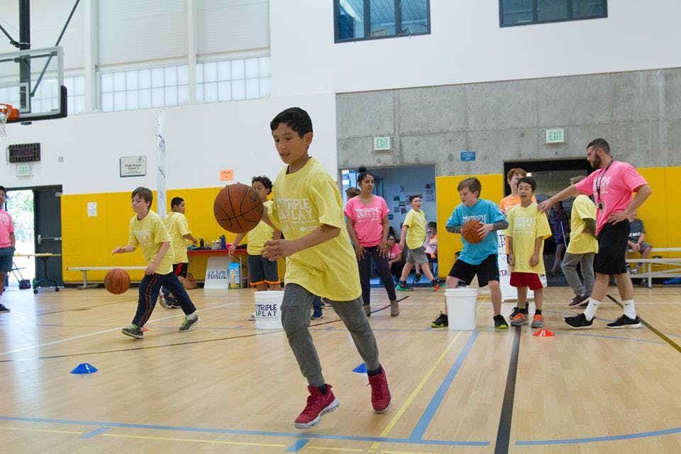 Children dribbling basketballs in a gymnasium