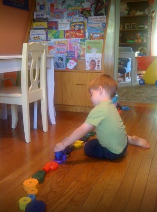 Child sitting on floor playing with colorful toys