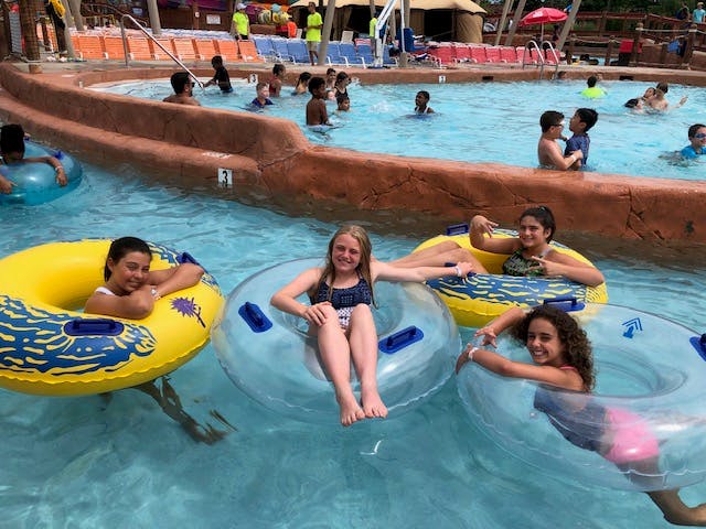 Children and teens floating in inner tubes in a lazy river