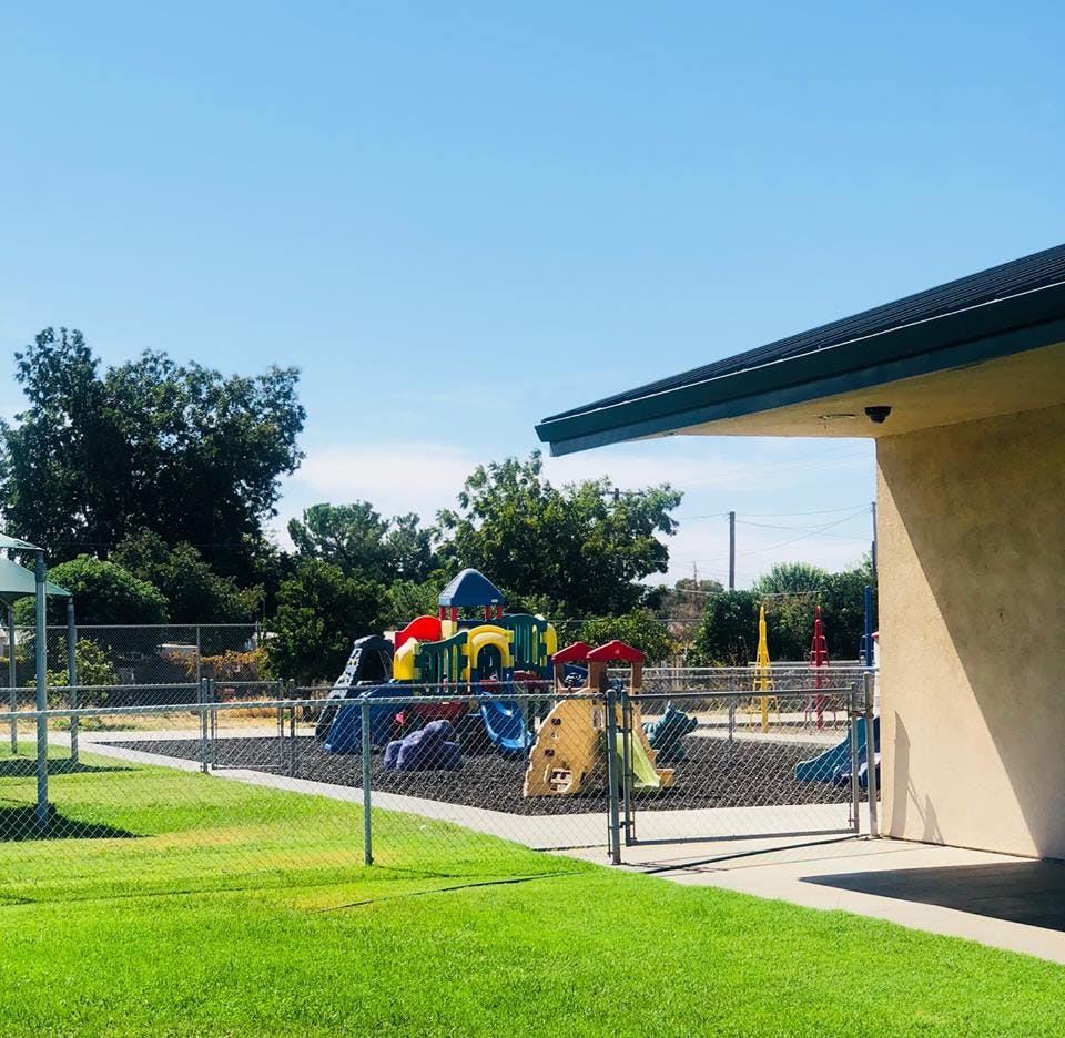 Playground with colorful equipment behind a chain-link fence