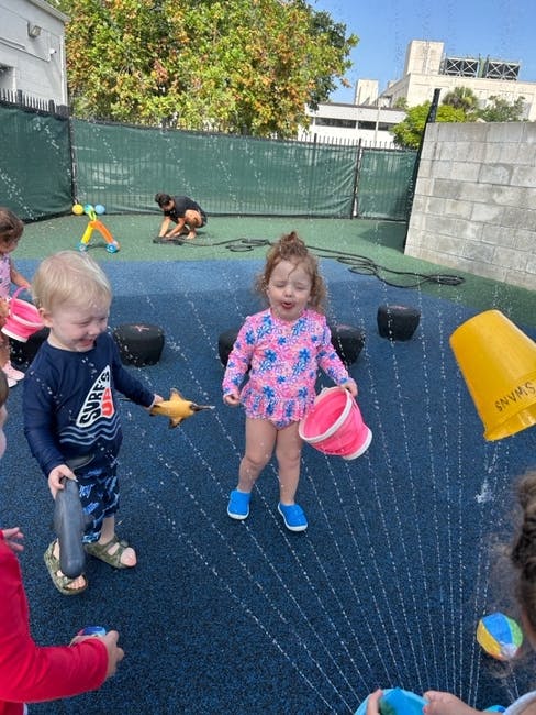 Children playing with water and buckets outdoors