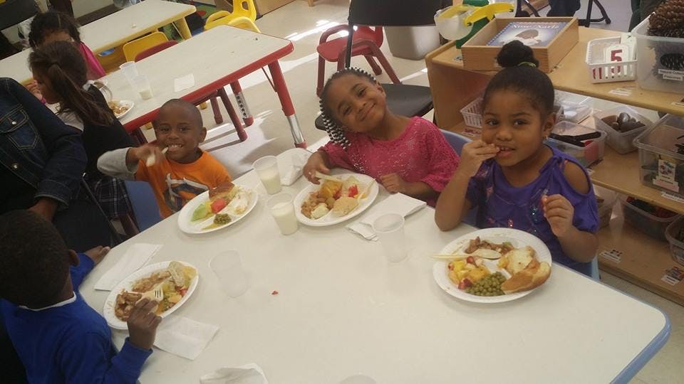Children eating at a table in a classroom