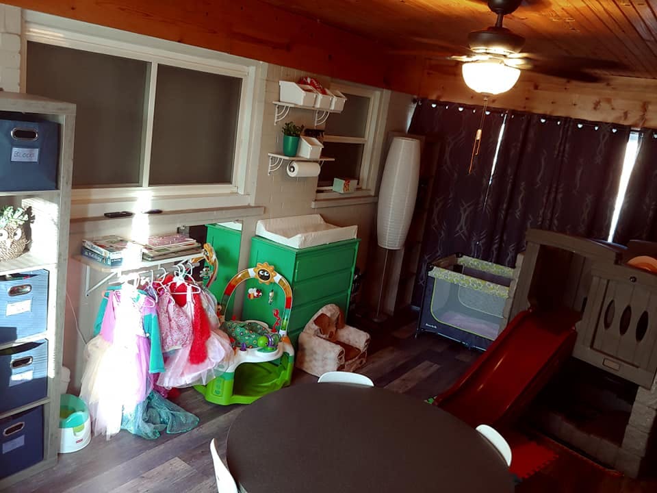 Children's play area with clothes, toys, and a red slide