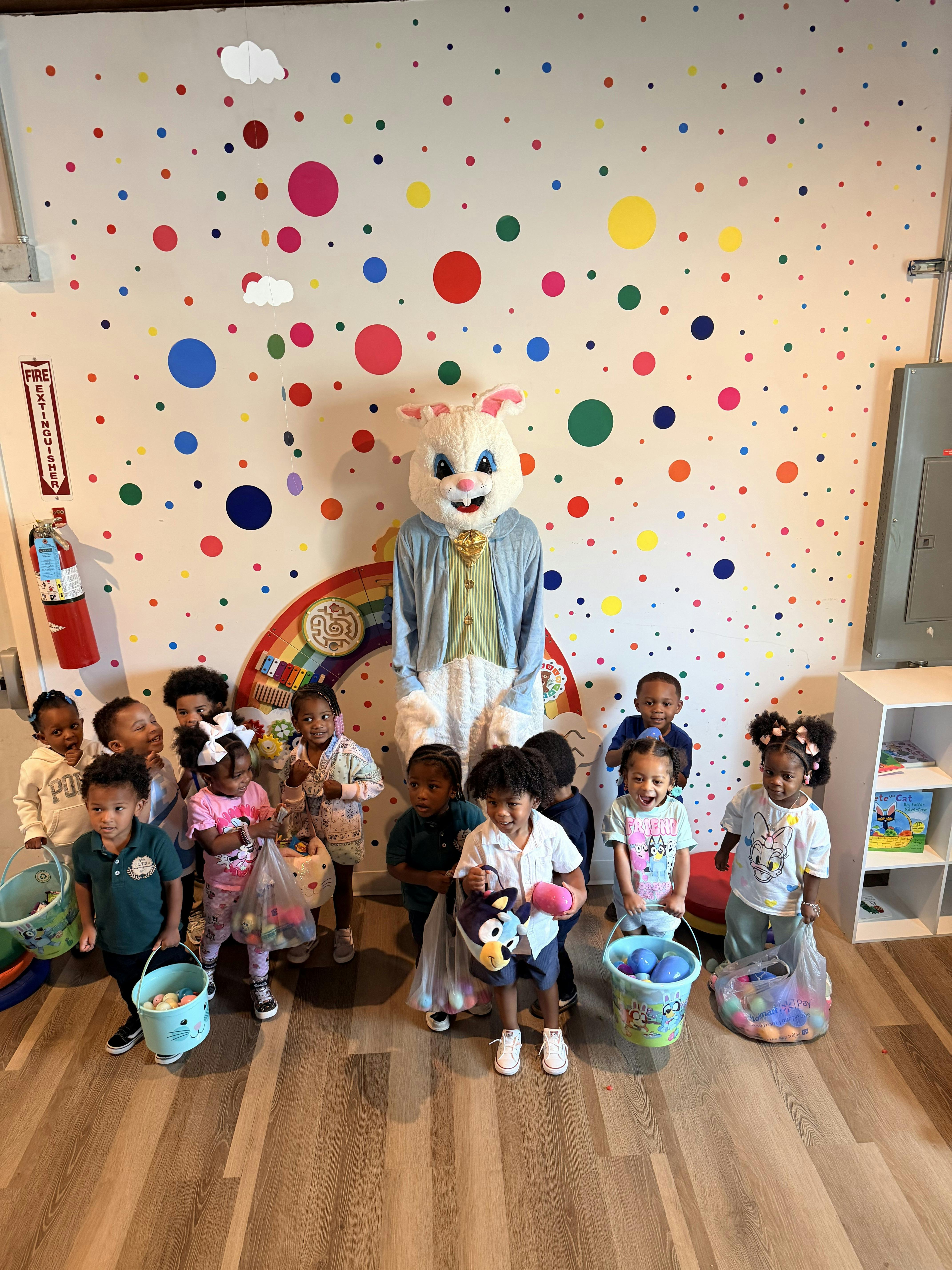 A group of children posing with an Easter Bunny mascot
