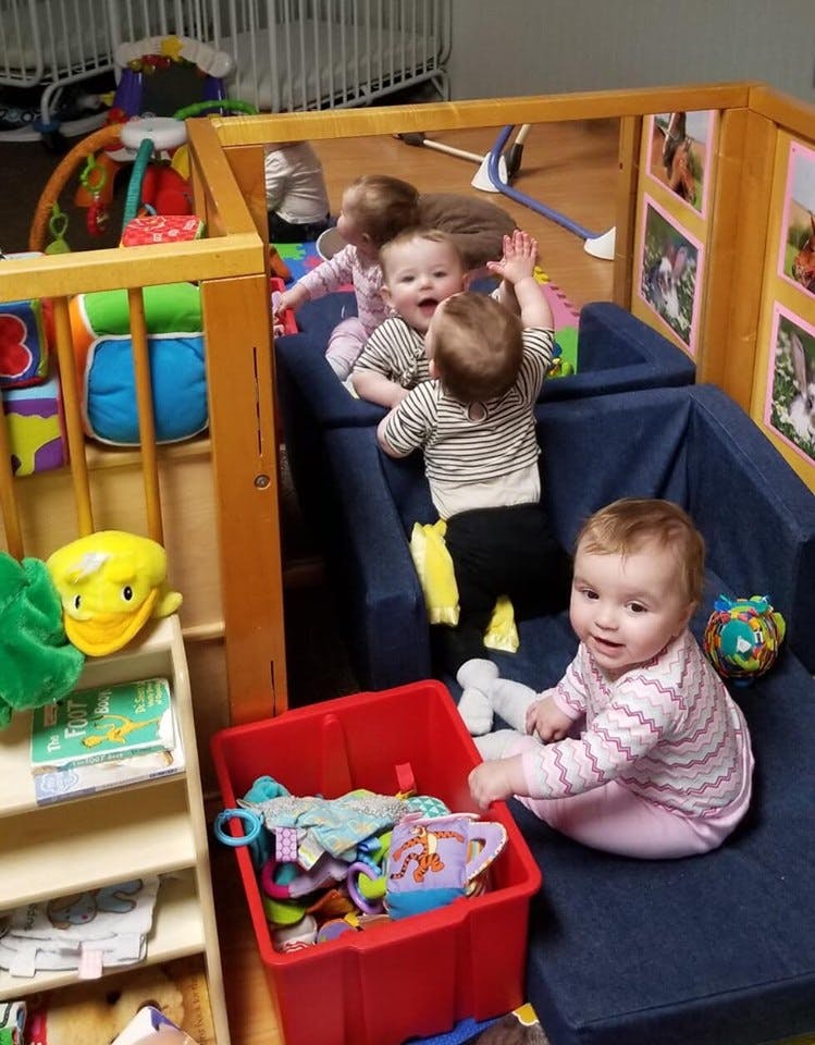 Multiple children playing in a playpen with soft blocks
