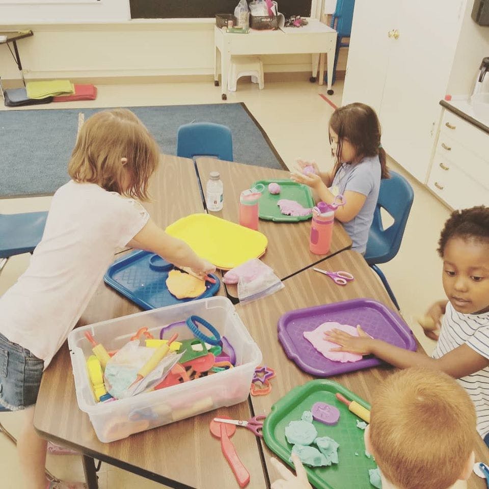 Children playing with modeling clay at a table