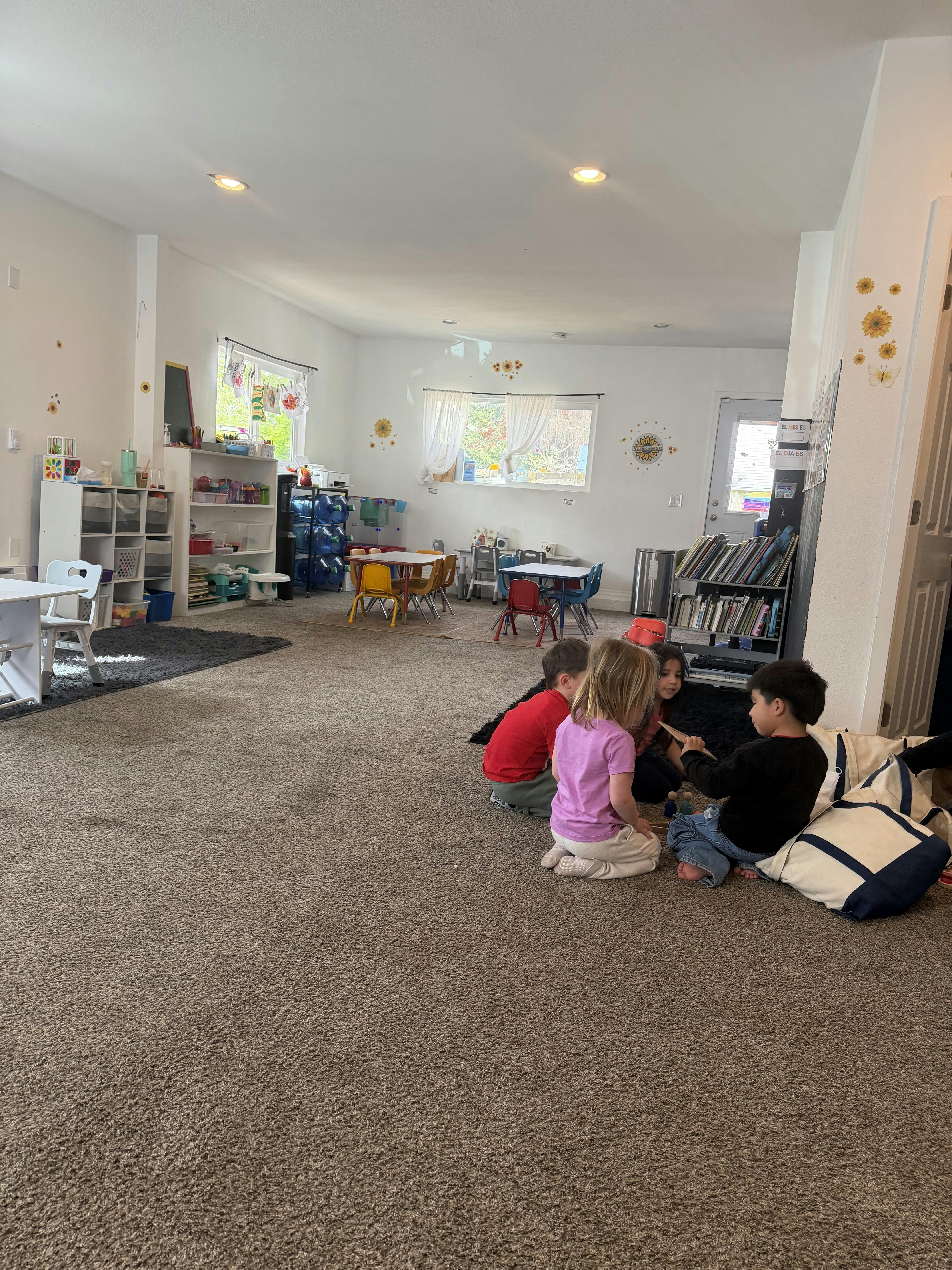 Children sitting on a carpeted floor in a classroom