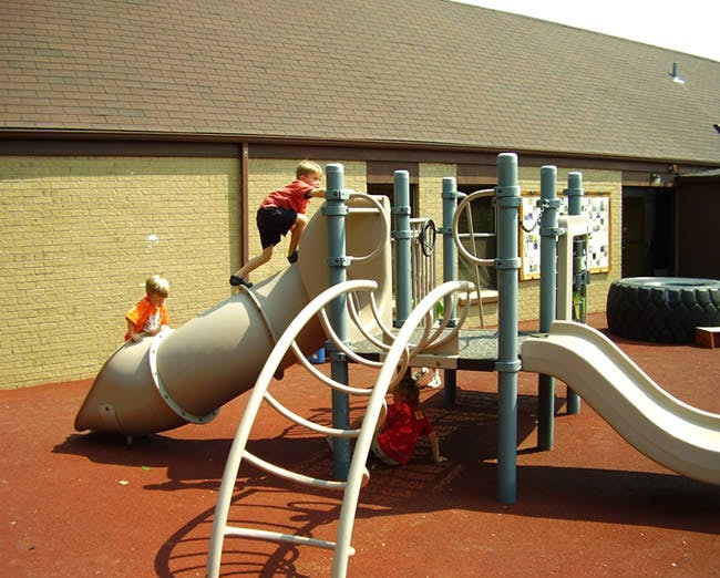 Children playing on a playground slide structure