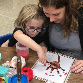 Adult and child painting together