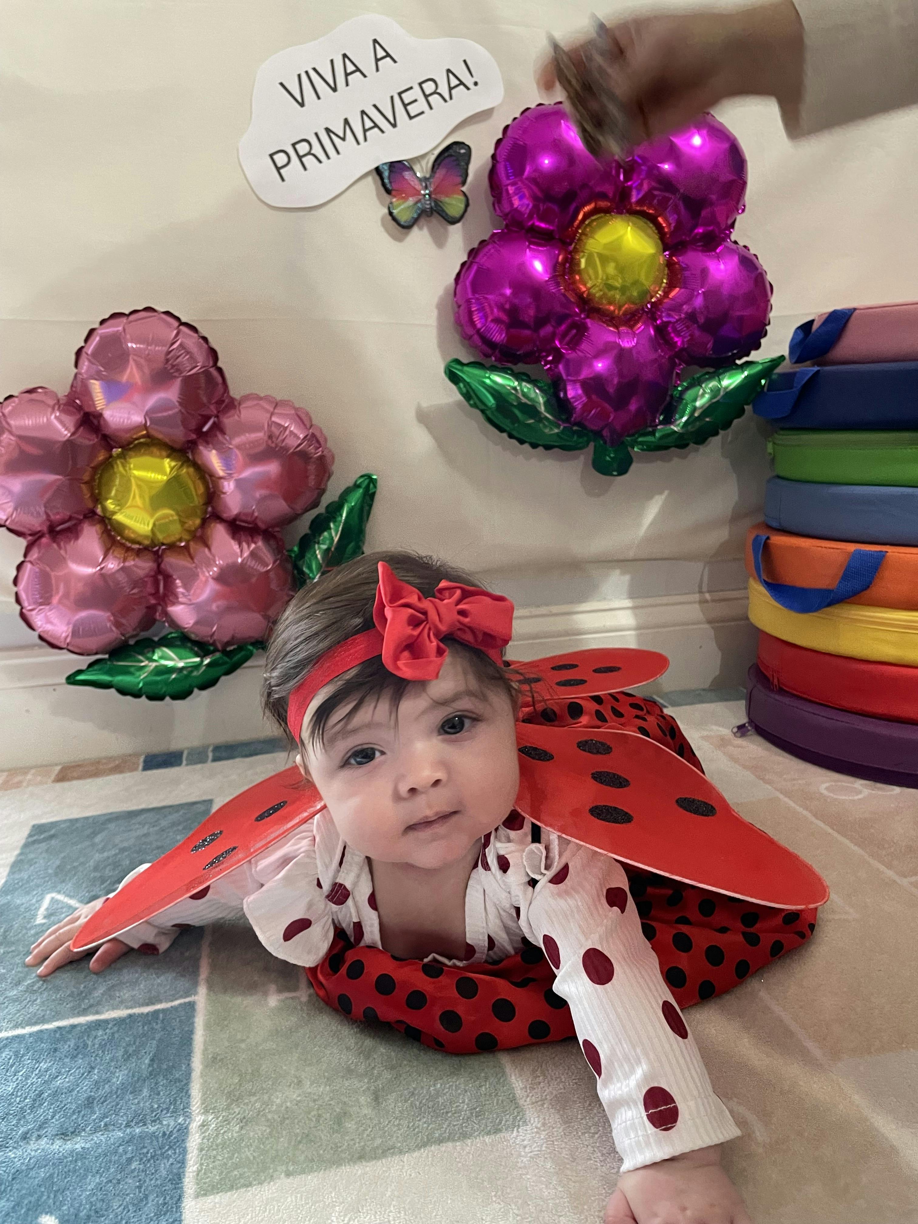 Child in a ladybug costume with a red bow headband