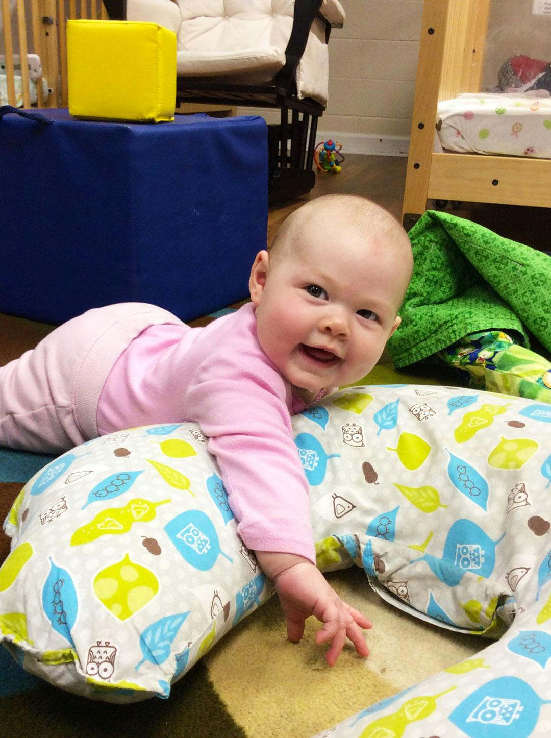 Child on stomach, propped up by a patterned pillow