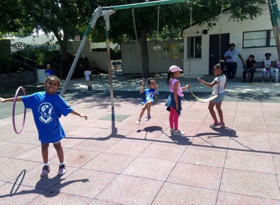 Children playing with a hula hoop and jump rope on a playground