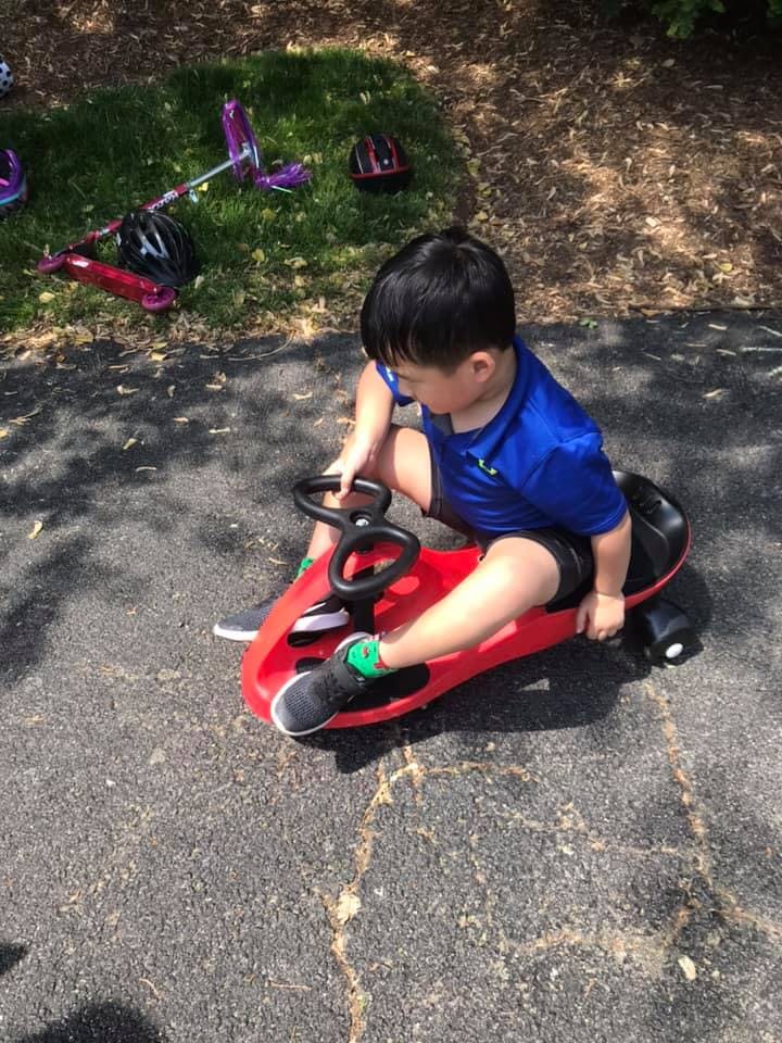 Child sitting on a red ride-on toy