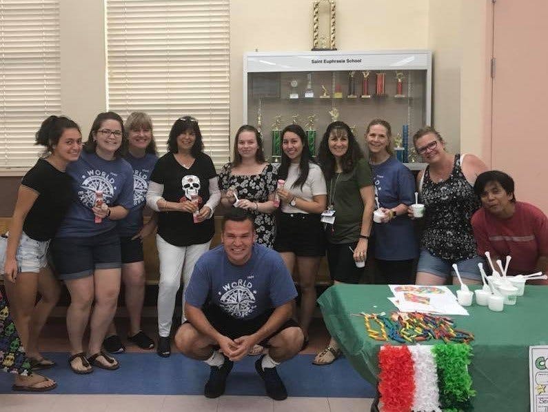 Group of adults posing with treats, some holding cups or colorful items