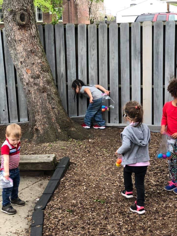 Children collecting colorful eggs in bags outdoors