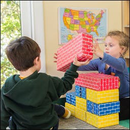 Two children playing with colorful building blocks