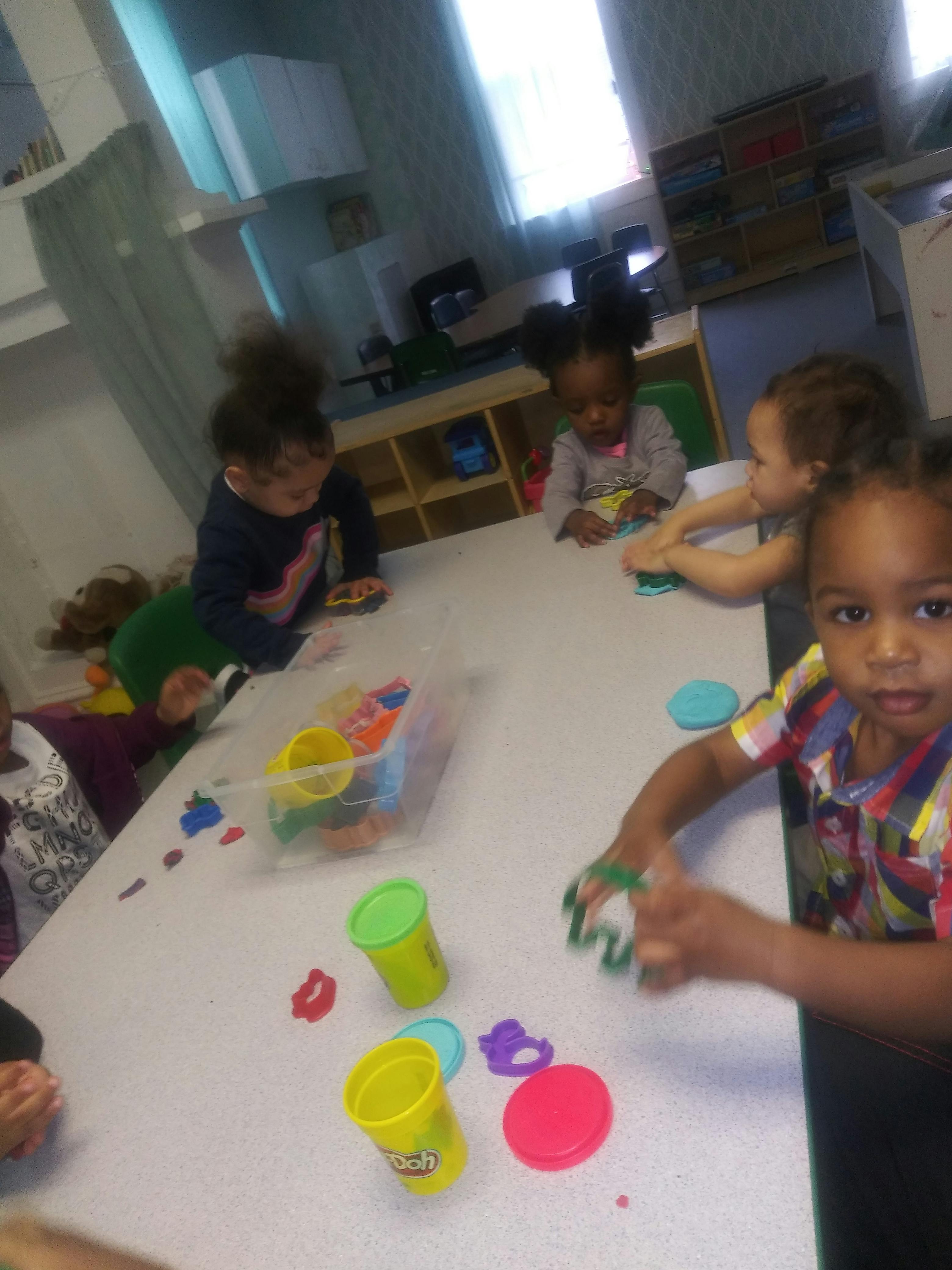 Children playing with colorful playdough at a table