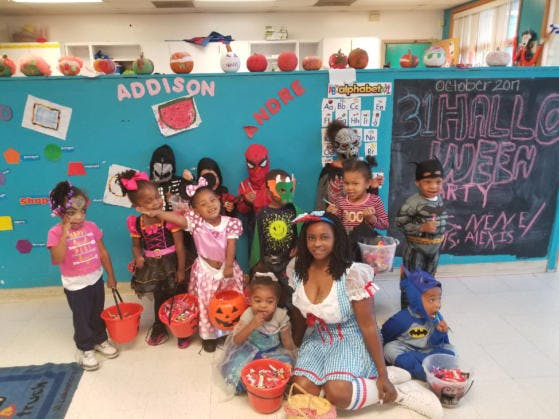 Adult and children in Halloween costumes holding buckets