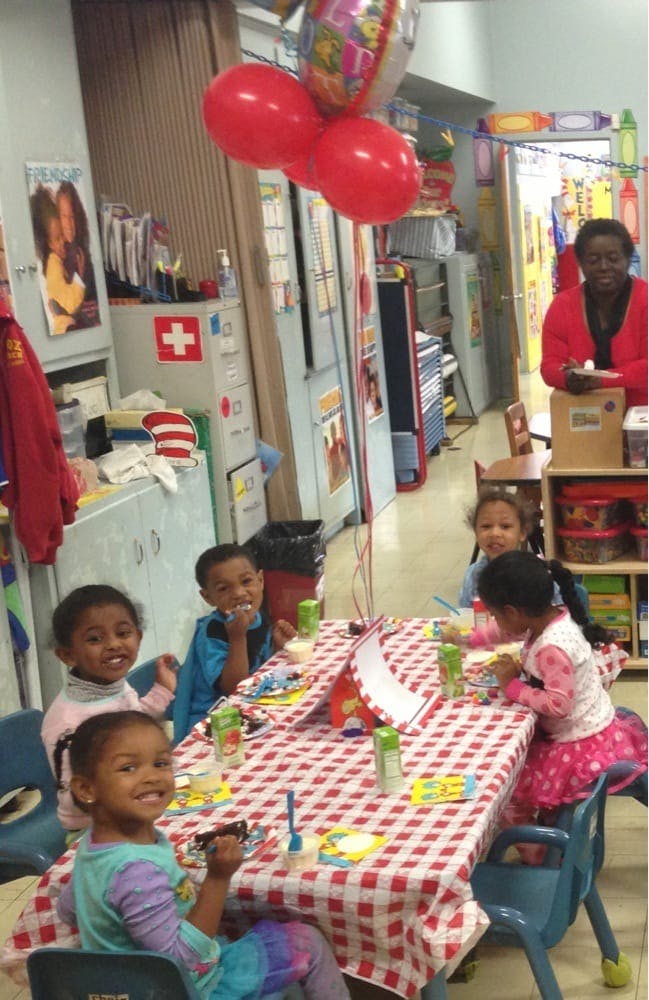 Children sitting at a table with a red and white checkered tablecloth