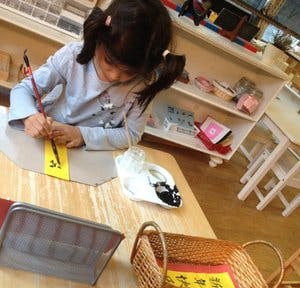 Child drawing on paper at a table